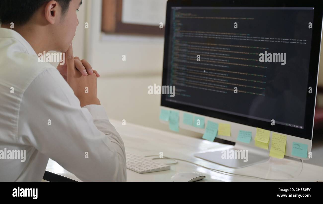 Programmer checks the code on a computer with a stressful expression ...