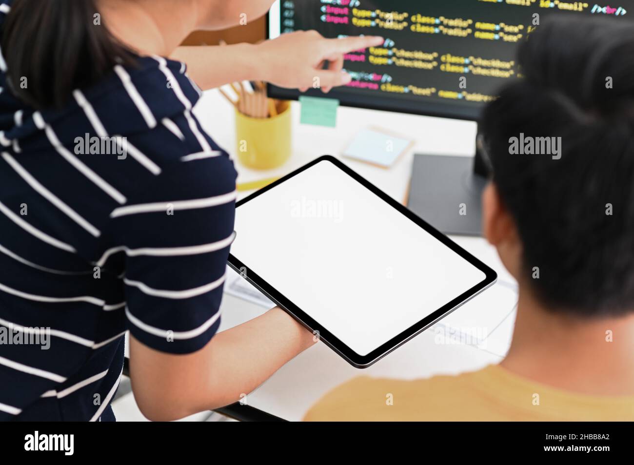 Team of programmers with tablet and computer is programming to present customers. Stock Photo