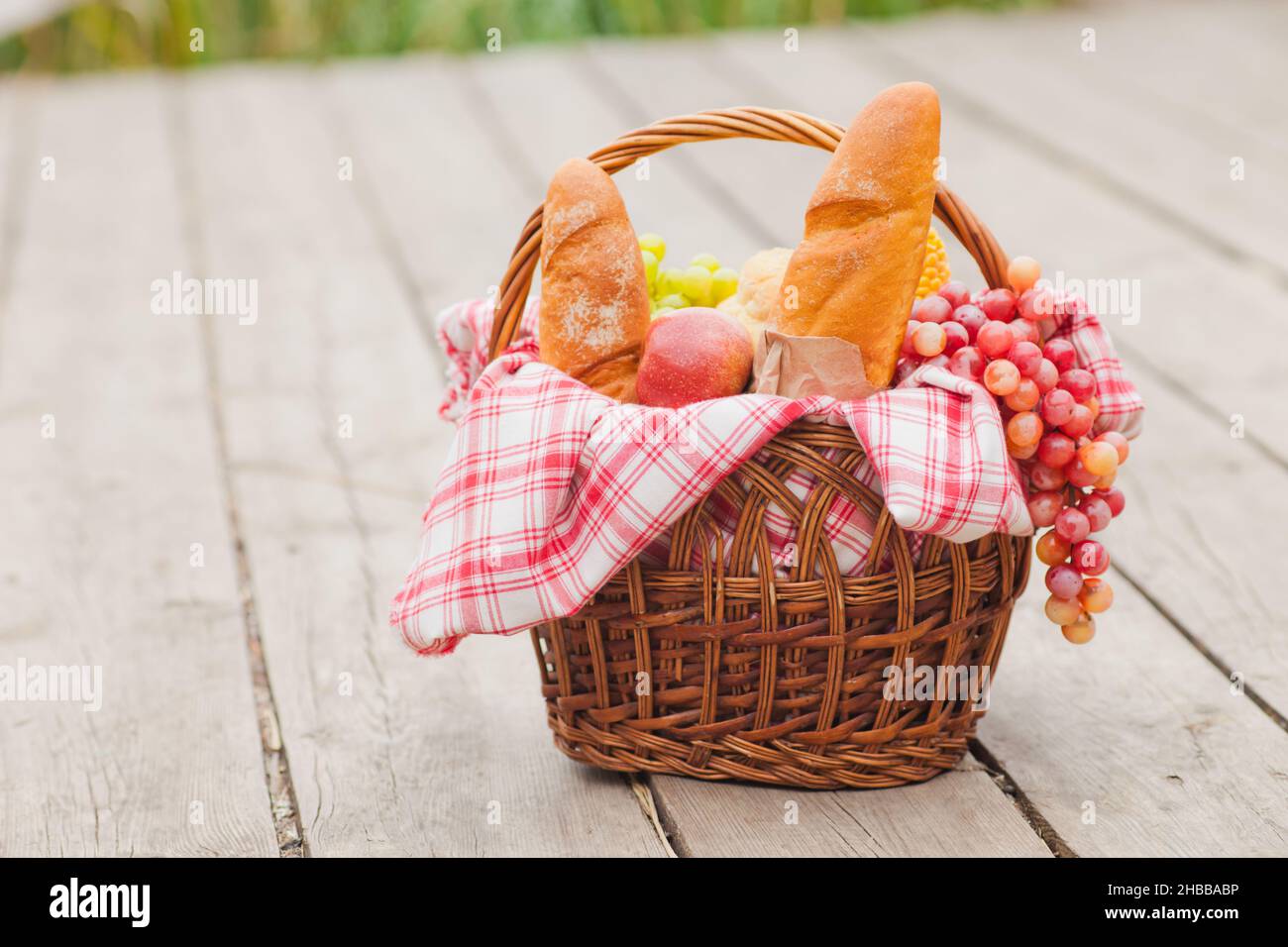 French provincial picnic. Retro style picnic basket with food on wooden