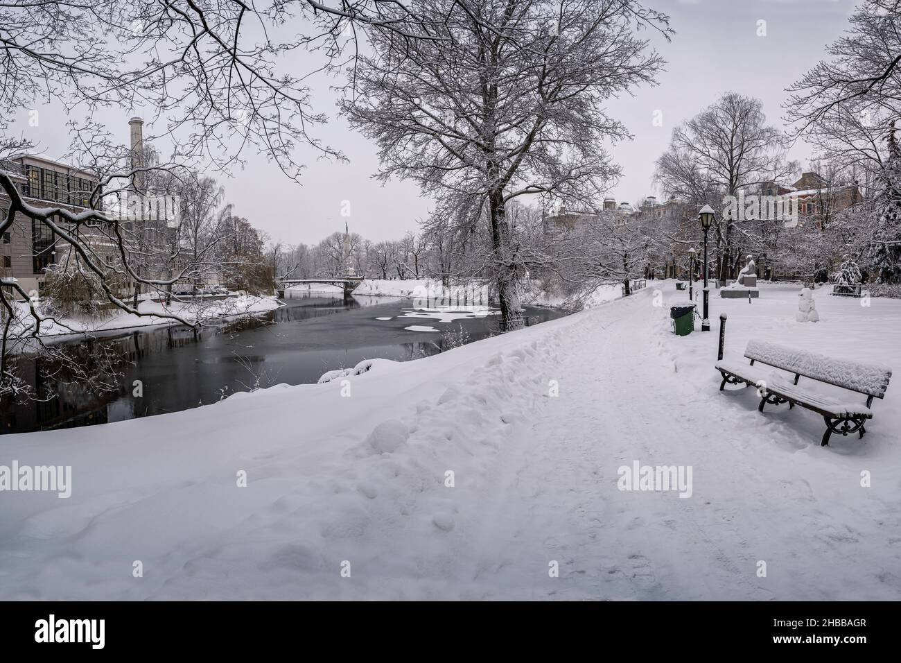 Covered in snow bench and canal in winter park. Winter landscape in ...