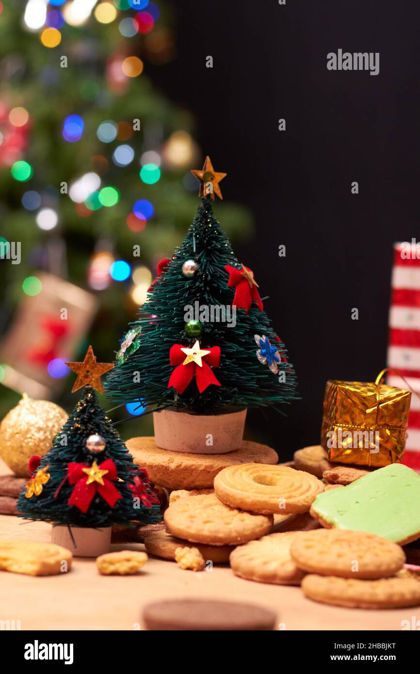 Vertical shot of tiny Christmas trees on cookies with a glowing tree in