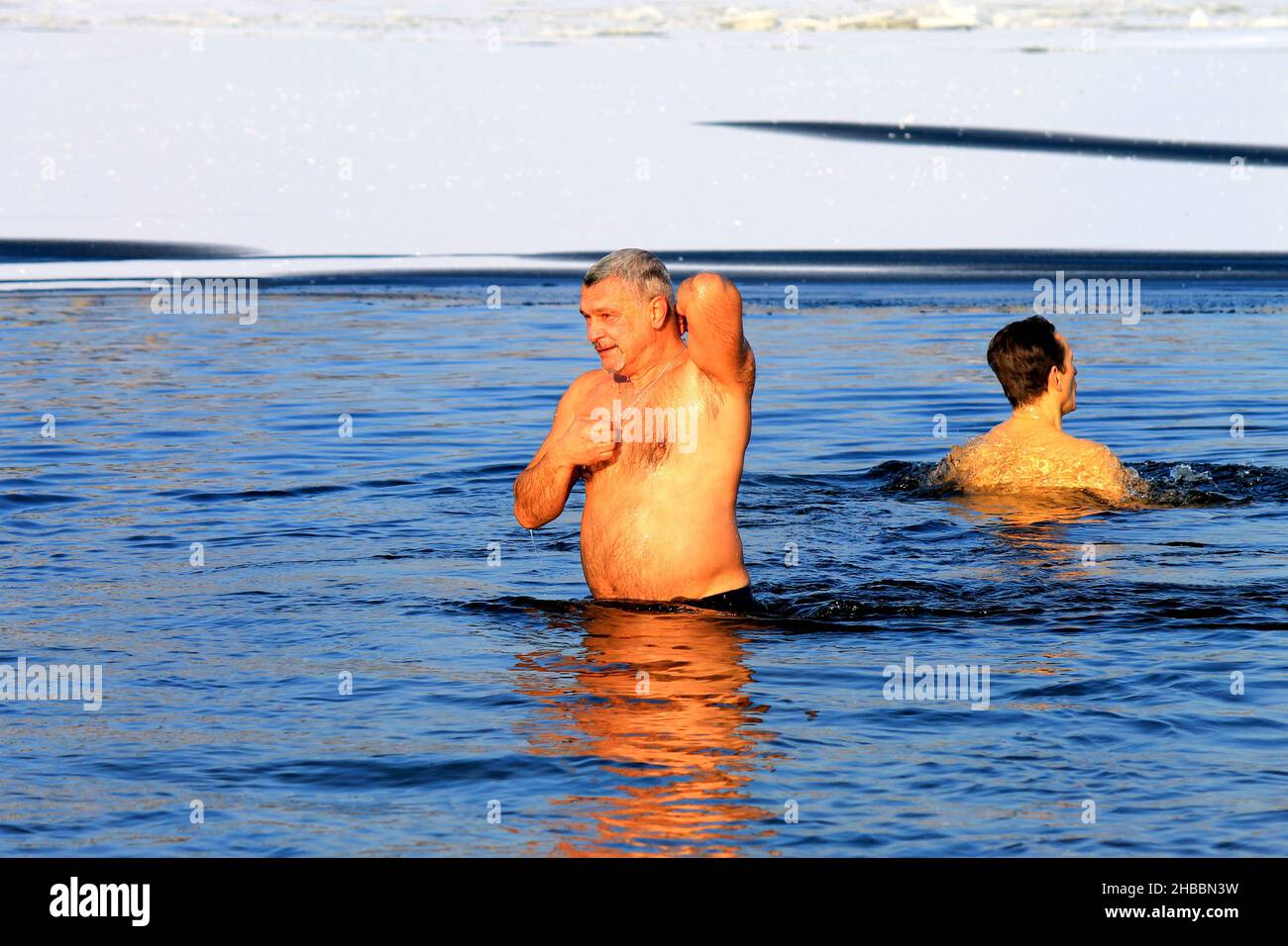 Winter swimming, hardening. Men swim in a river covered with ice during the Orthodox holiday of Epiphany. Winter sport, Dnipro, Ukraine, Dnepr, 2020 Stock Photo