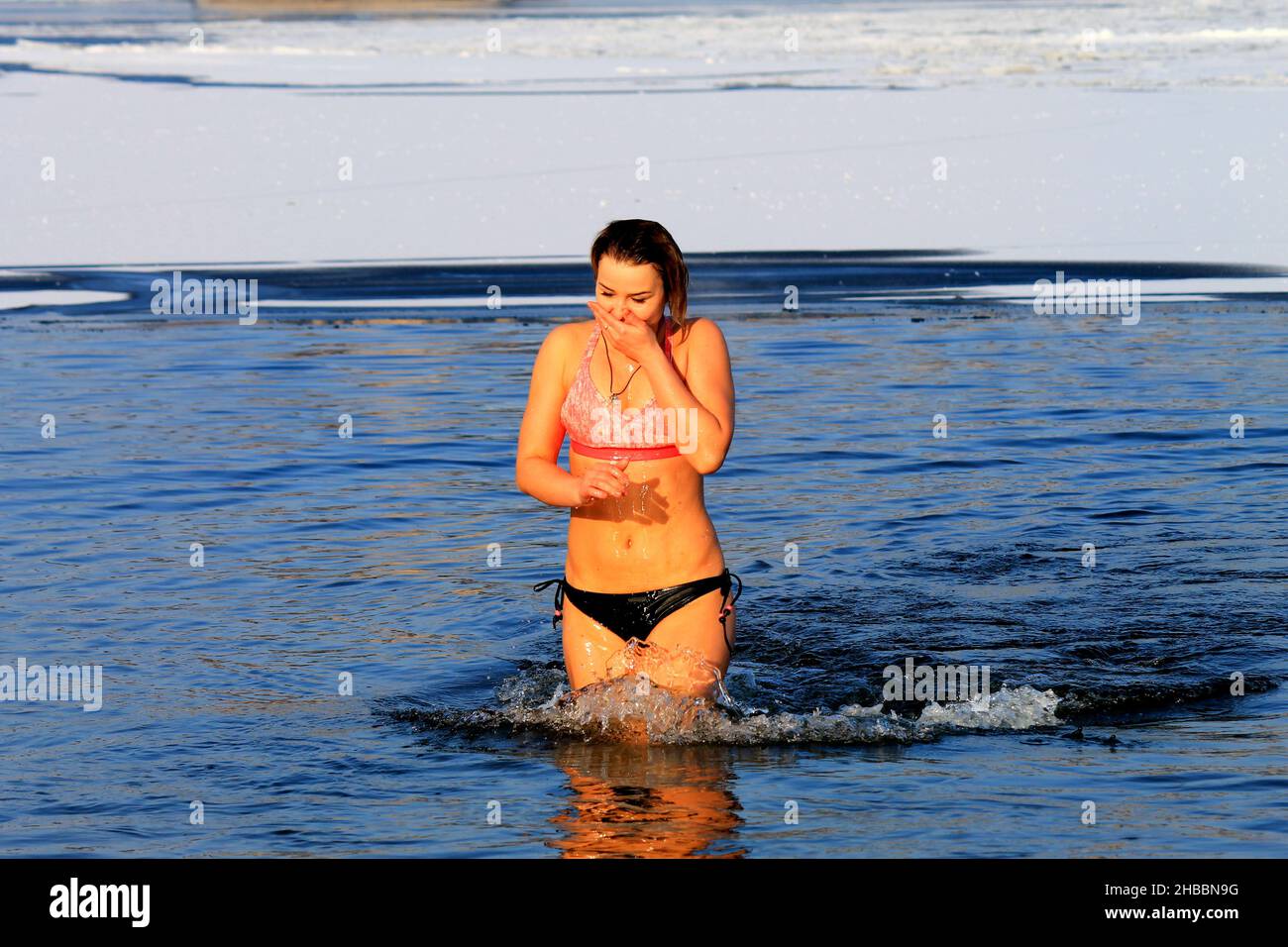 Winter swimming, hardening, woman swim in a river covered with ice during the Orthodox holiday of Epiphany. Winter sport, Dnipro, Ukraine, Dnepr, 2020 Stock Photo