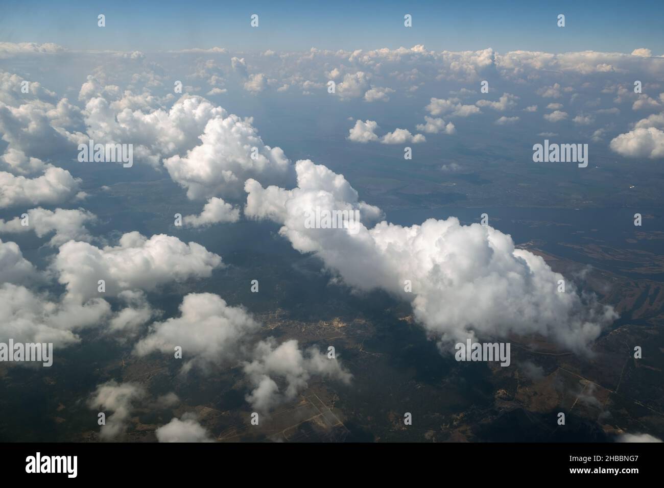 Aerial view from airplane window of white puffy clouds on bright sunny ...