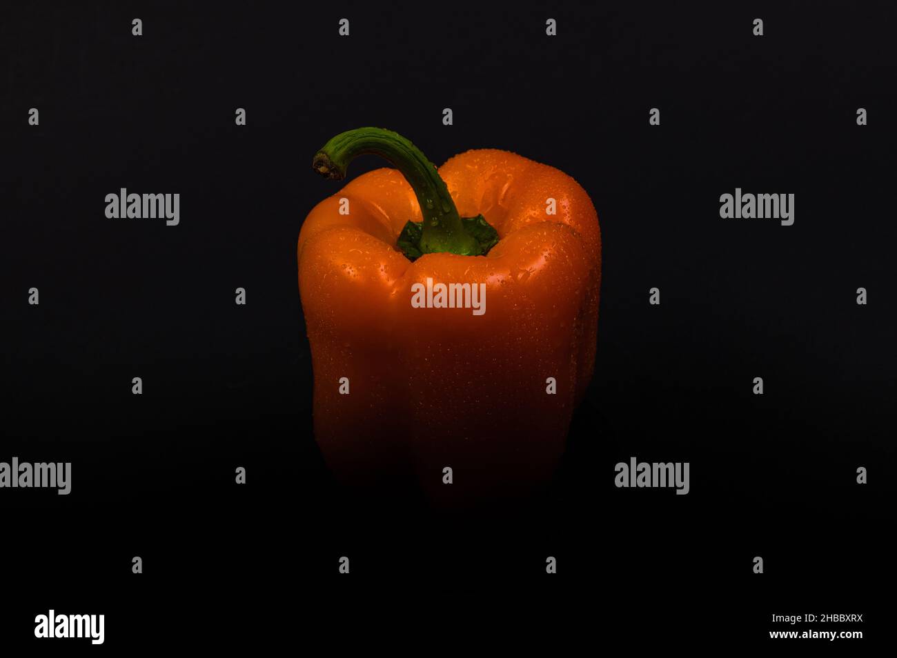 Orange bell pepper with water drops on a black background Stock Photo