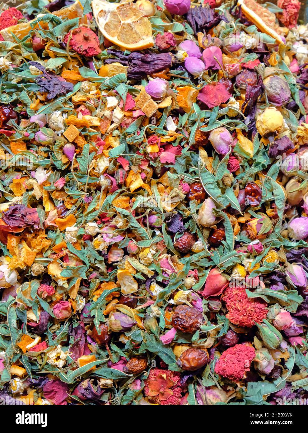 Food background texture of green tea with flower rose petals and fruit pieces, organic healthy herbal leaves, detox tea. Stock Photo