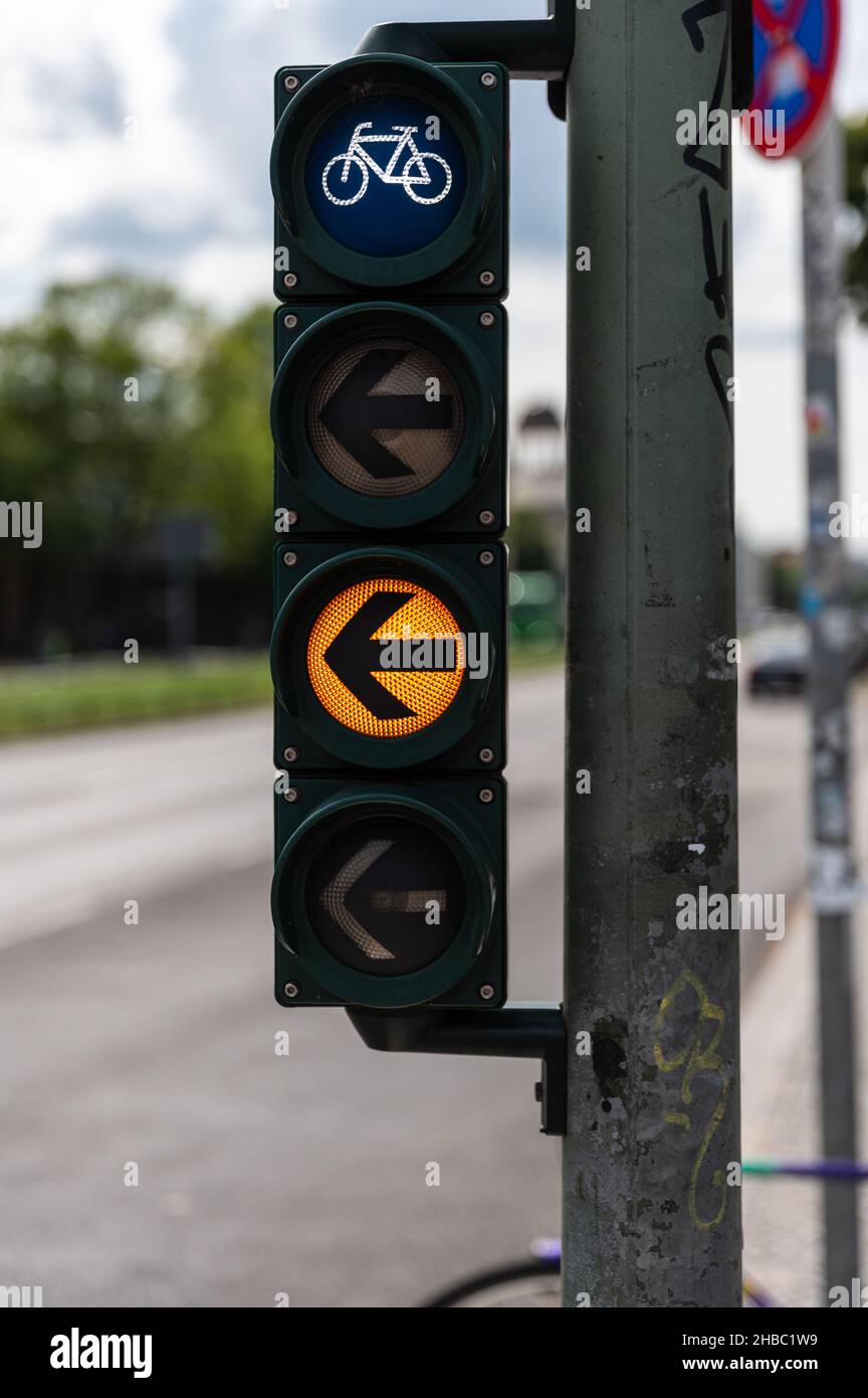 Bicycle traffic light with yellow light and arrow pointing to the left Stock Photo