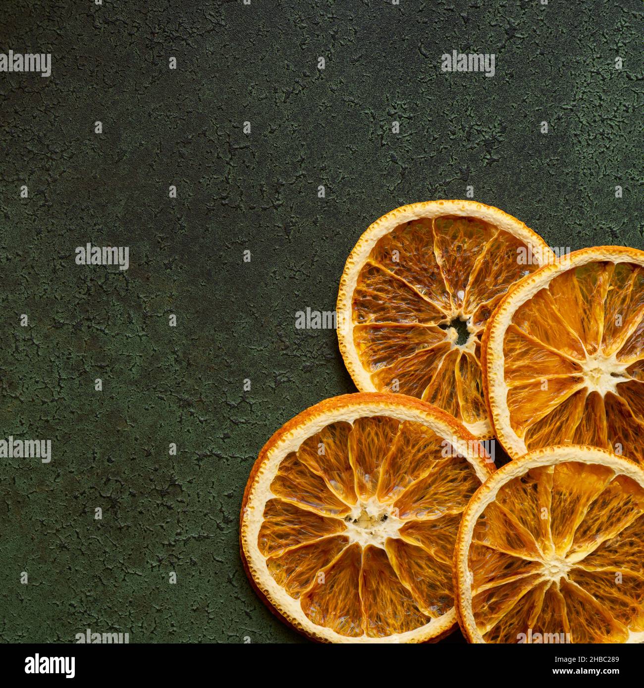 Dried orange slices on green background with copy space Stock Photo