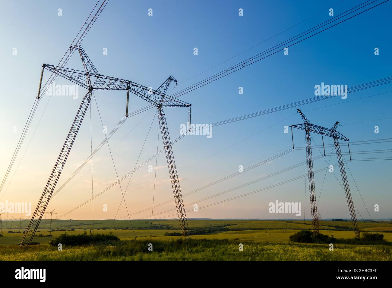 High voltage towers with electric power lines at sunset Stock Photo - Alamy