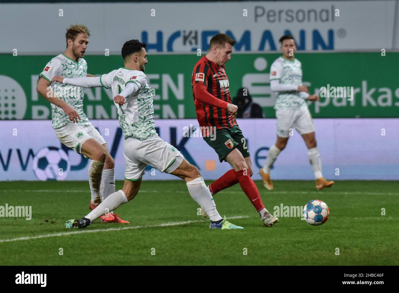 Germany ,Fuerth, Sportpark Ronhof Thomas Sommer - 18 Dec 2021 - Fussball, 1.Bundesliga - SpVgg Greuther Fuerth vs. FC Augsburg  Image: (fLTR) Sebastian Griesbeck (SpVgg Greuther Fürth,22), Maximilian Bauer (SpVgg Greuther Fürth,4), Andre Hahn (FC Augsburg, 28)  DFL regulations prohibit any use of photographs as image sequences and or quasi-video Credit: Ryan Evans/Alamy Live News Stock Photo
