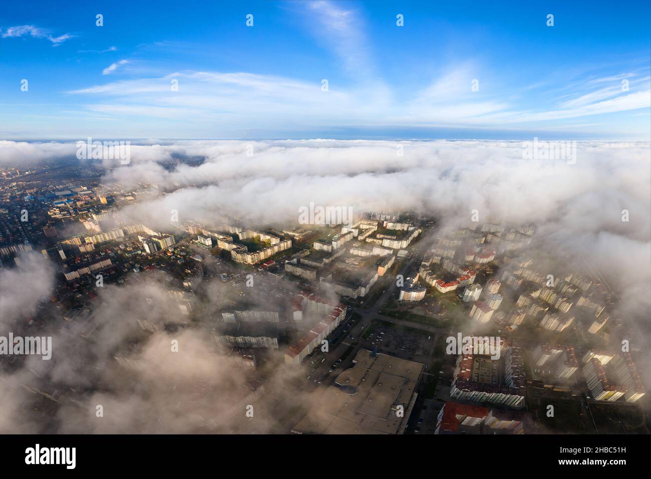 Top aerial view of fluffy white clouds over modern city with high rise ...