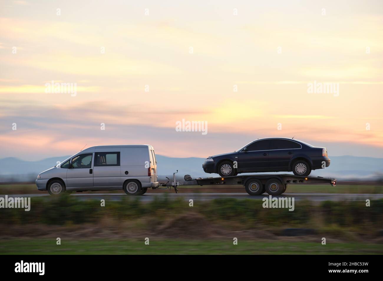 Tow truck vehicle with car transporting carrier trailer driving on ...