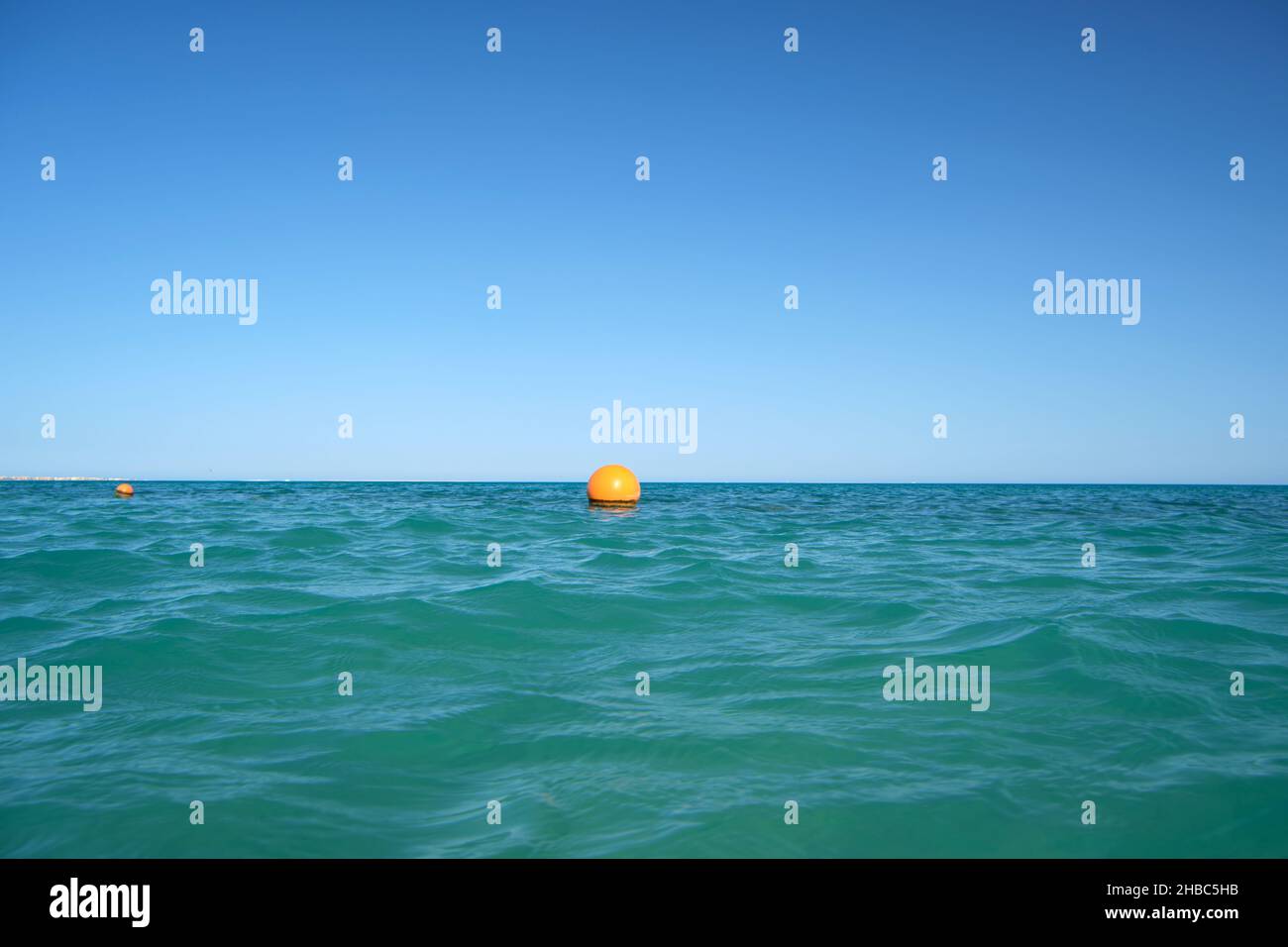Yellow buoy floating on sea surface as marker for swimming restriction