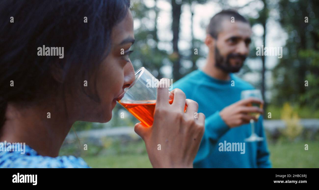 Shallow focus of young adult Indian friends drinking during a party in a garden Stock Photo