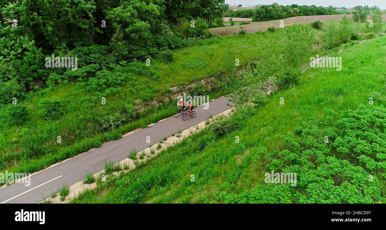 Aerial view of two friends biking together on paved 7 mile ...