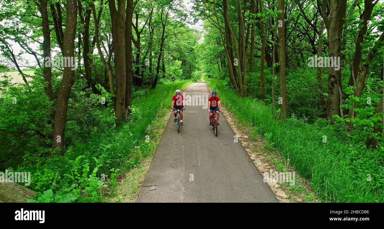 Aerial view of two friends biking together on paved 7 mile