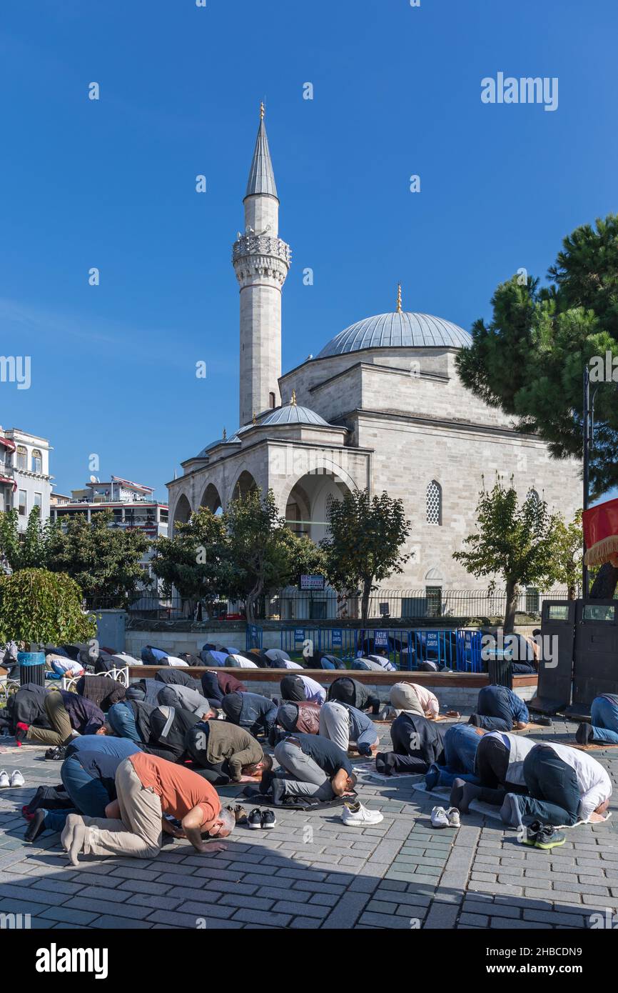 Muslims pray on a street in front of a mosque in Istanbul, Turkey Stock Photo