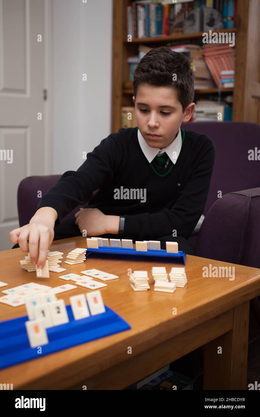A boy playing Rummikub and laying down a tile Stock Photo Alamy