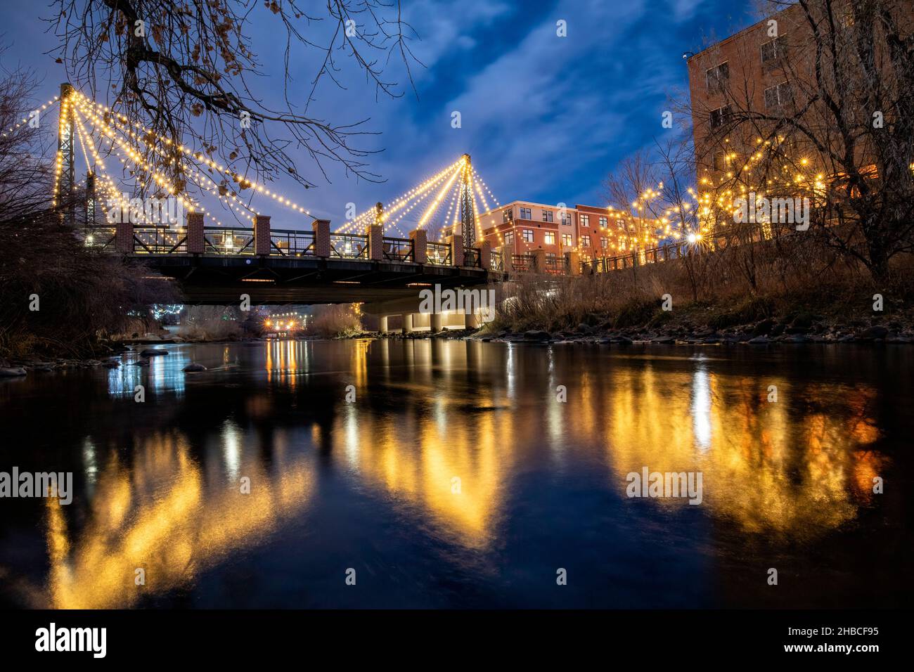 Washington Avenue Bridge illuminated with Christmas lights over Clear Creek in Golden, Colorado, USA Stock Photo