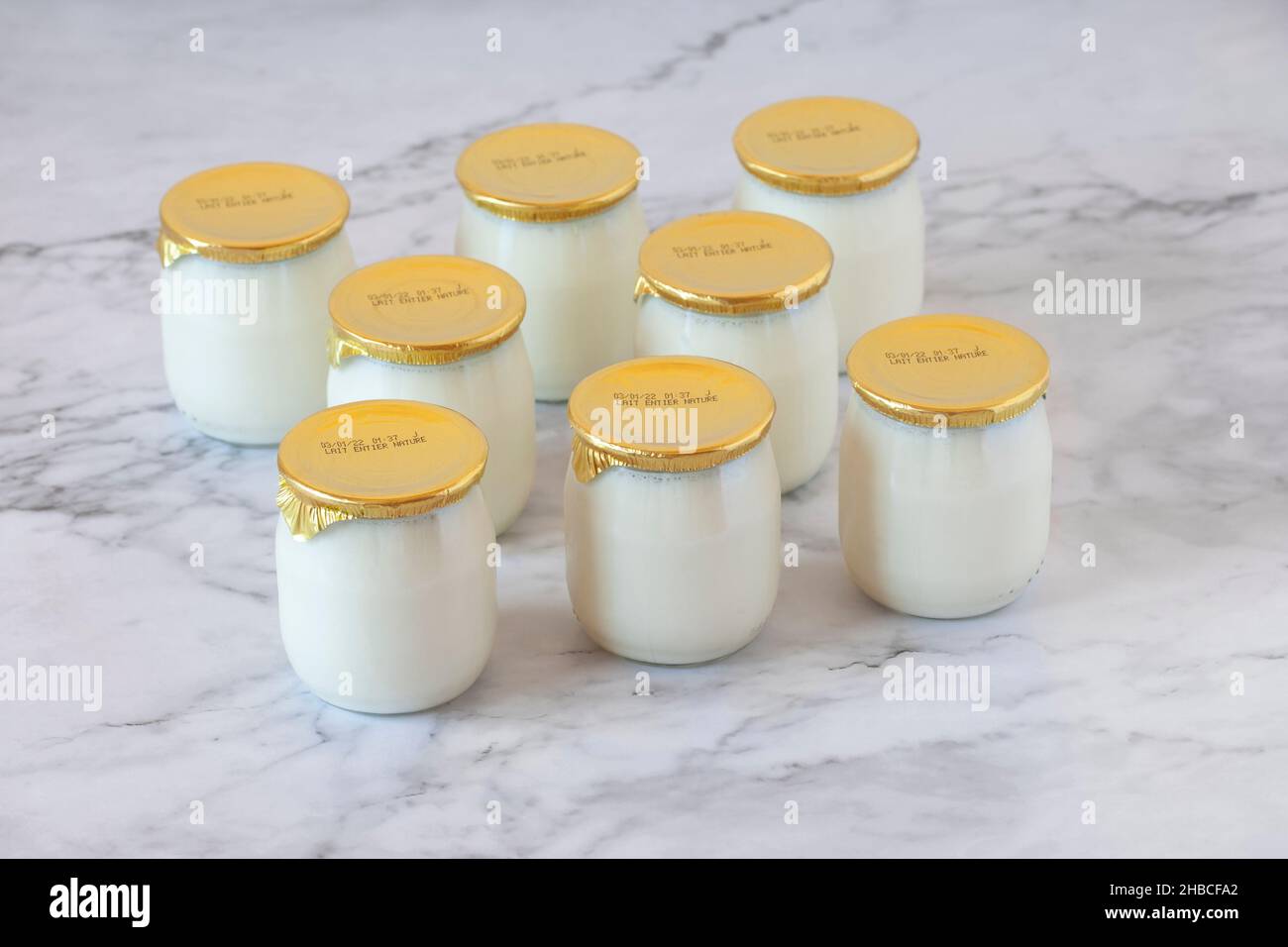natural whole milk industrial yogurt in glass pots with the expiration