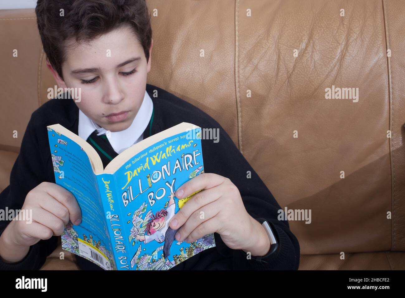 A school boy reading, Billionaire Boy by David Walliams Stock Photo