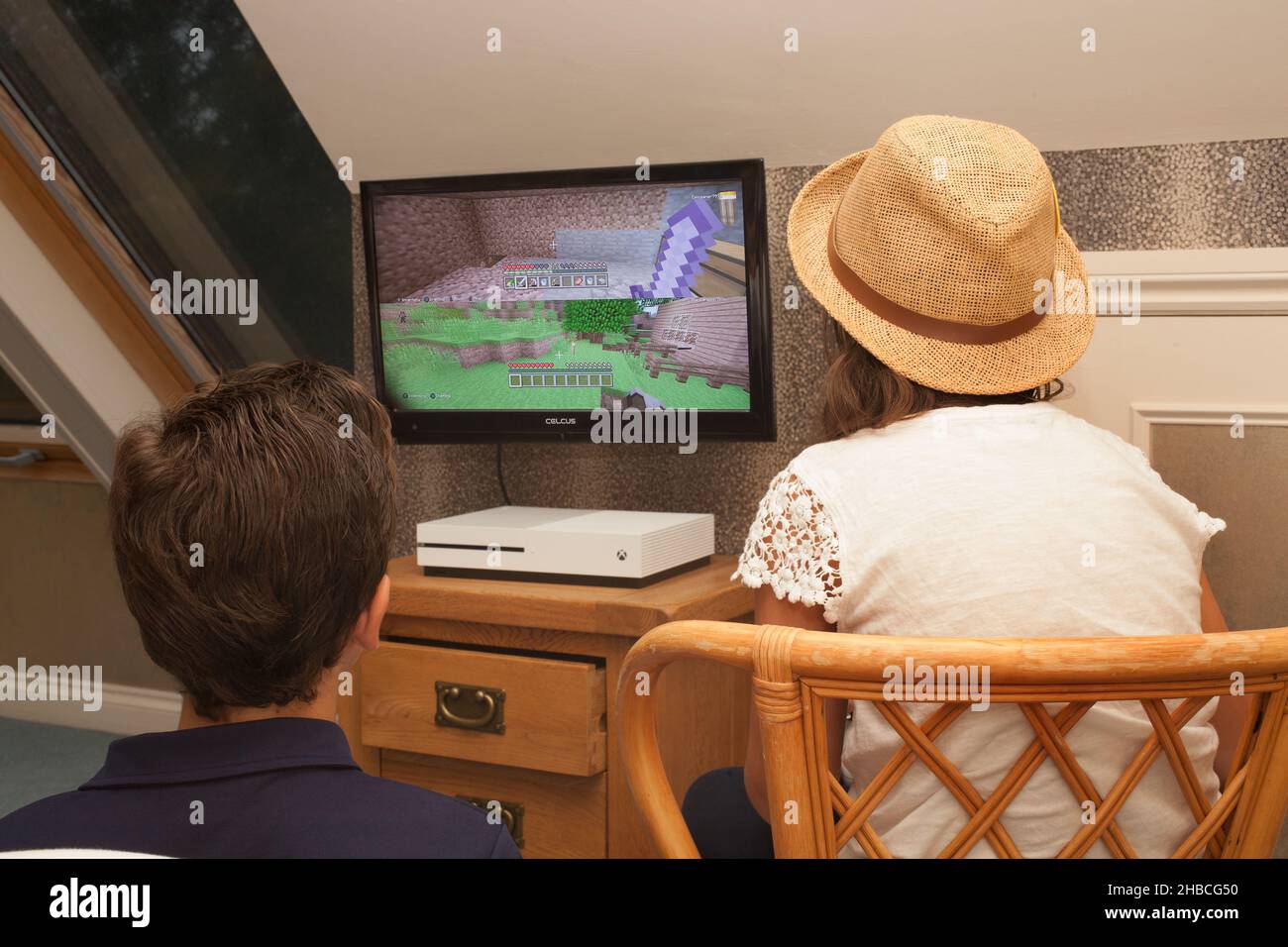 A brother and sister playing the computer game Minecraft on an Xbox, taken on the 13th of August in Wool, Dorset, UK Stock Photo