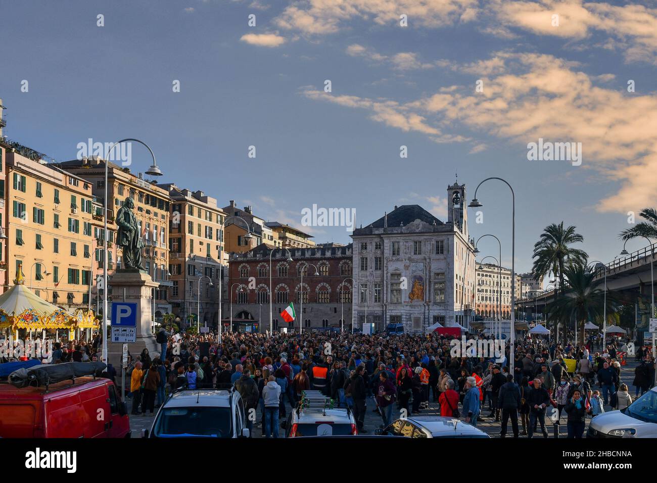 Genoa, Liguria, Italy - 10 23 2021: Crowd of people at a No Green Pass protest rally in Piazza Caricamento, with Palazzo San Giorgio in the background Stock Photo