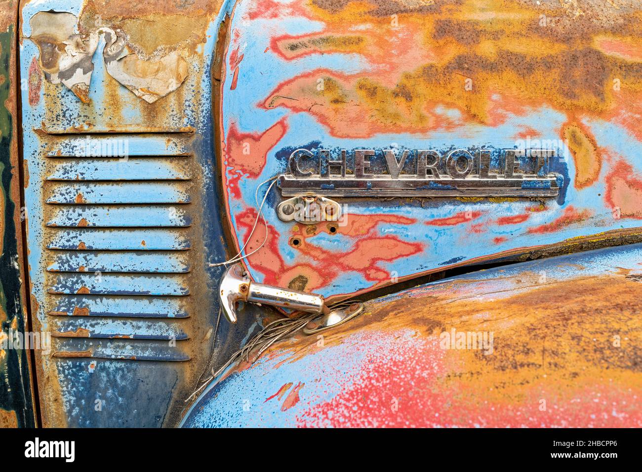 Detail of the nameplate and hood latch on a 1949 Chevy truck in a junkyard in Idaho, USA Stock Photo