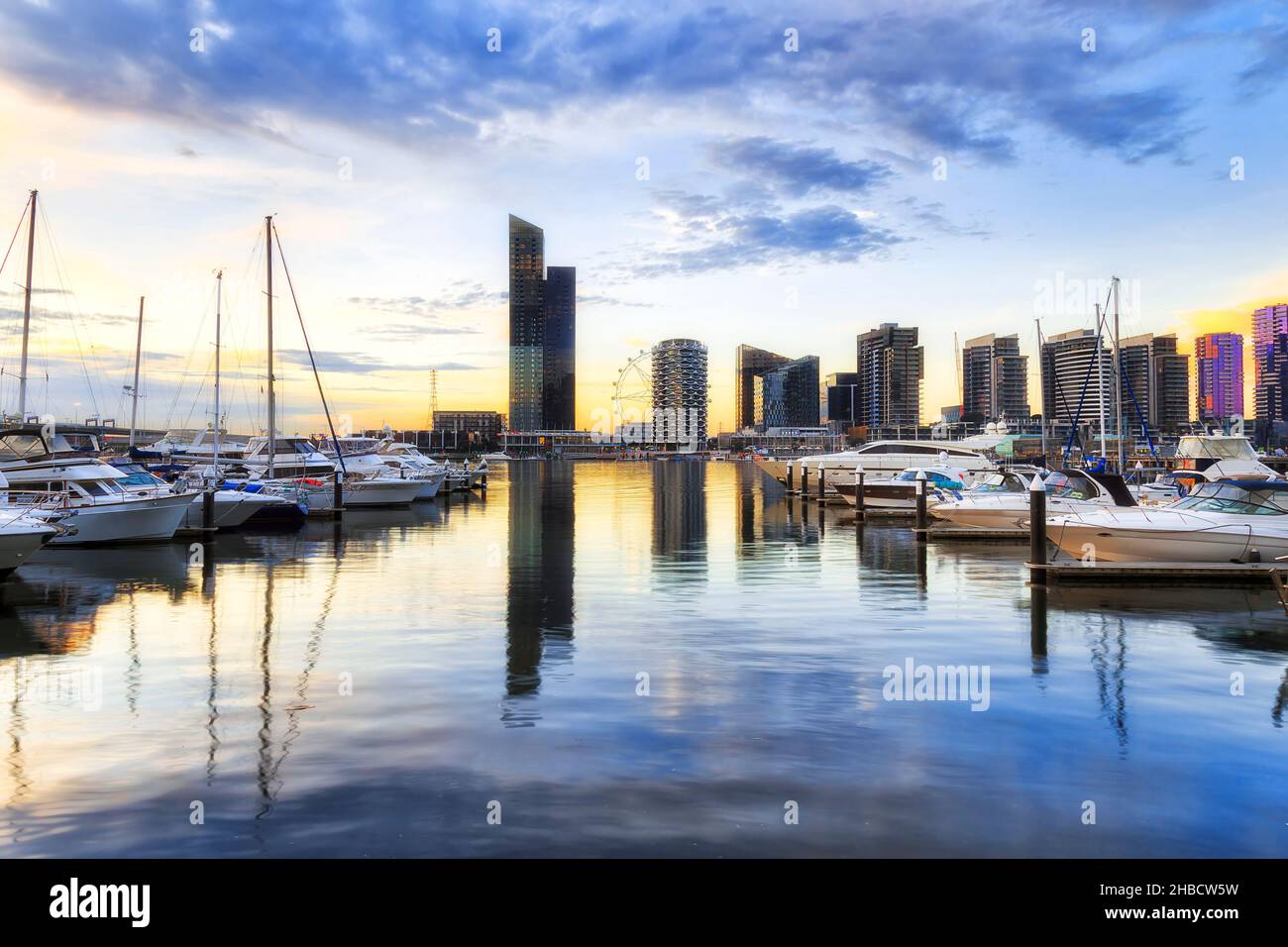 Marina with modern yachts and motor boats on yarra river in Docklands suburb of Melbourne city at sunset. Stock Photo