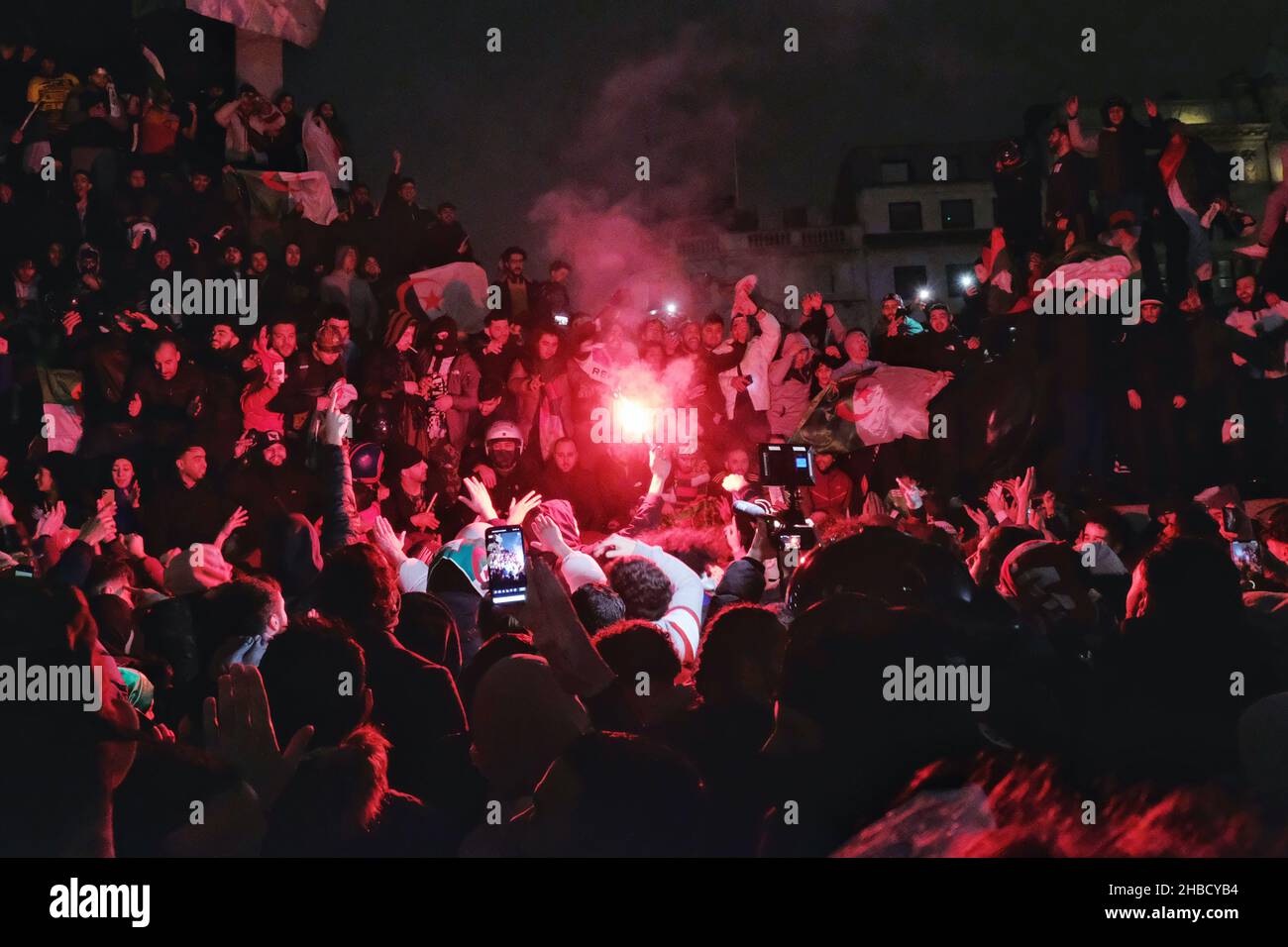 London, UK, 18th Dec, 2021. Hundreds of Algeria football fans gather in Trafalgar Square after a 2-0 victory against Tunisia in the 2021 FIFA Arab Cup, scoring the goals in extra-time.  Revellers set off dozens upon dozens of fireworks and flares in the square and at the foot of Nelson's Column - a location traditionally known for celebrating football fans. Credit: Eleventh Hour Photography/Alamy Live News Stock Photo