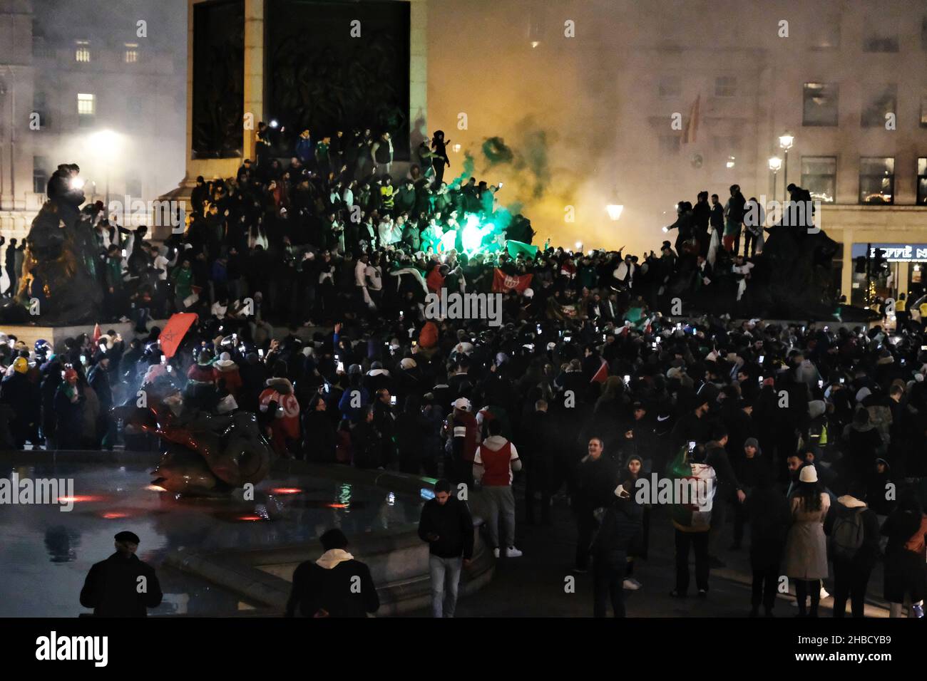 London, UK, 18th Dec, 2021. Hundreds of Algeria football fans gather in Trafalgar Square after a 2-0 victory against Tunisia in the 2021 FIFA Arab Cup, scoring the goals in extra-time.  Revellers set off dozens upon dozens of fireworks and flares in the square and at the foot of Nelson's Column - a location traditionally known for celebrating football fans. Credit: Eleventh Hour Photography/Alamy Live News Stock Photo