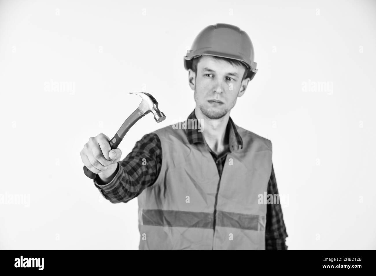Guy knoking shiny metal hammer master repair wear helmet uniform, professional tools concept Stock Photo