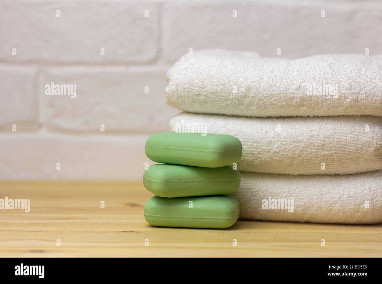 A stack of clean white towels and soap on the table Stock Photo