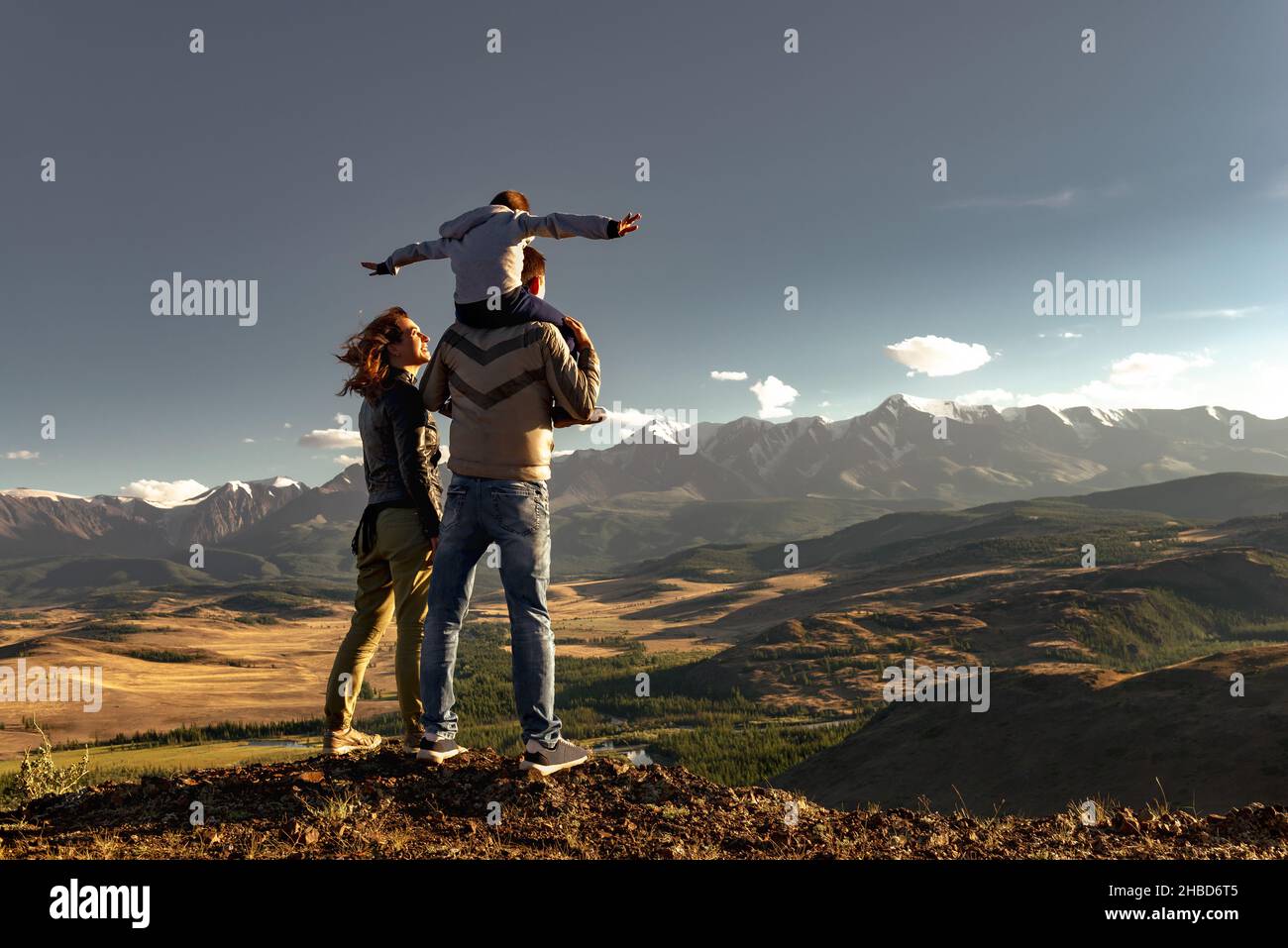 Happy family of mother father and young son walks in mountains. Active weekend travel concept Stock Photo