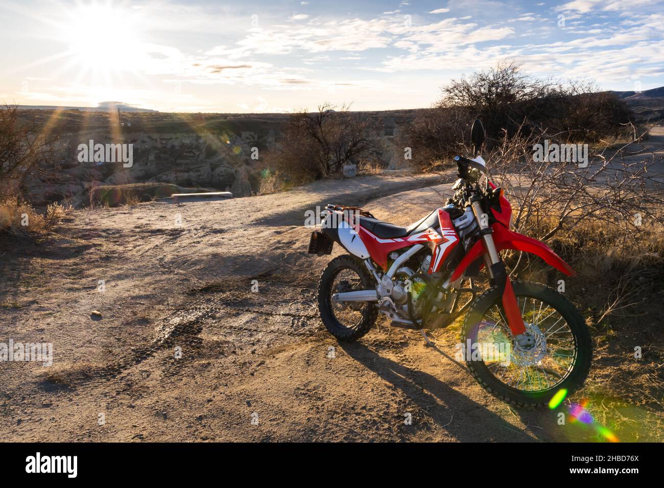 Red cool cross race motorcyle stands in front of Goreme town in Cappadocia during the sunrise. Background horizontal photo. Extreme sports.2019.12.15. Stock Photo