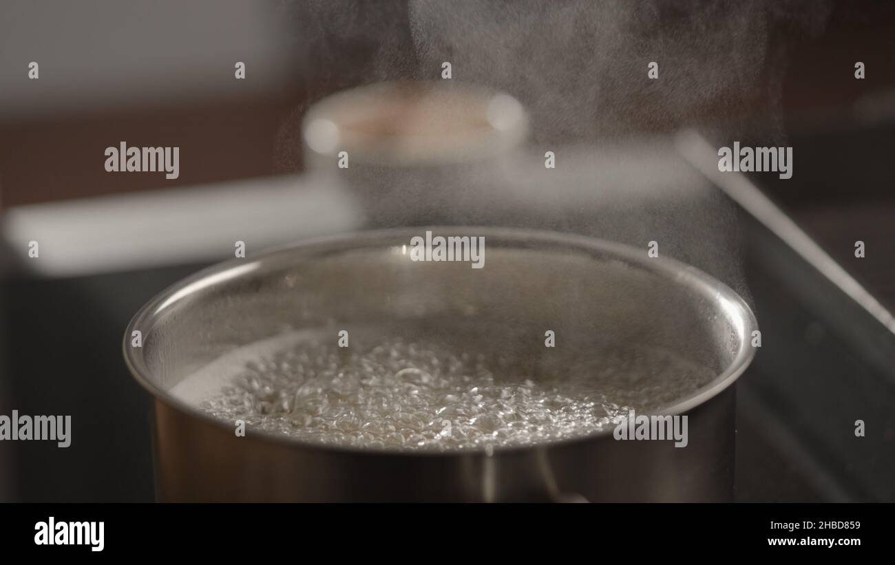 Premium Photo  Salt is added to boiling water pot on electric induction hob