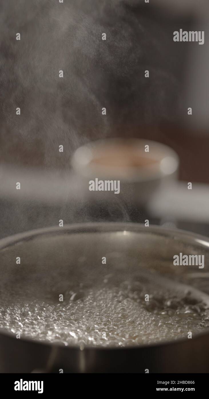 vertical shot pasta boiling in saucepan on induction stove, vertical photo Stock Photo
