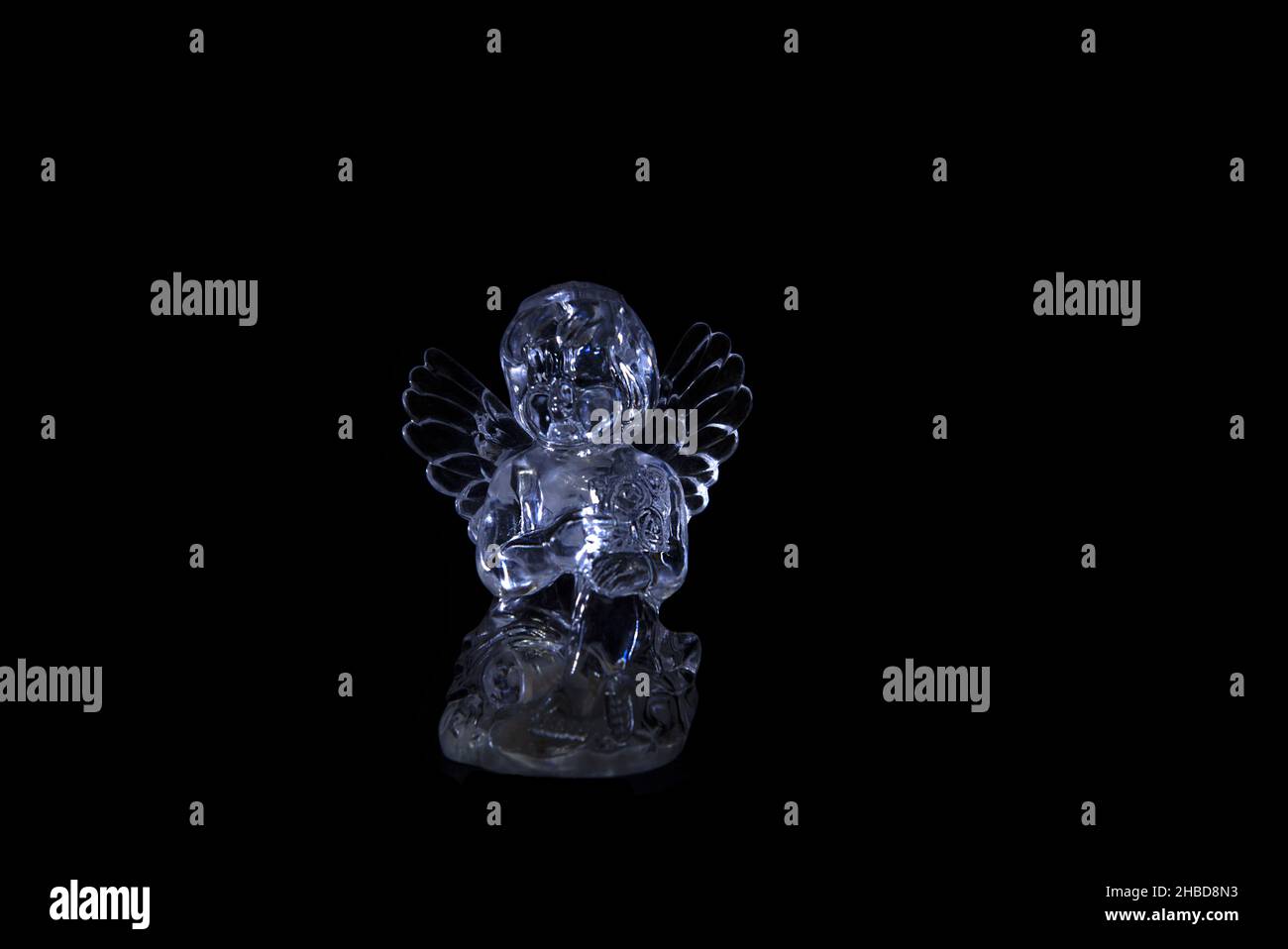little angel in the darkness. Figurine made by glass Stock Photo
