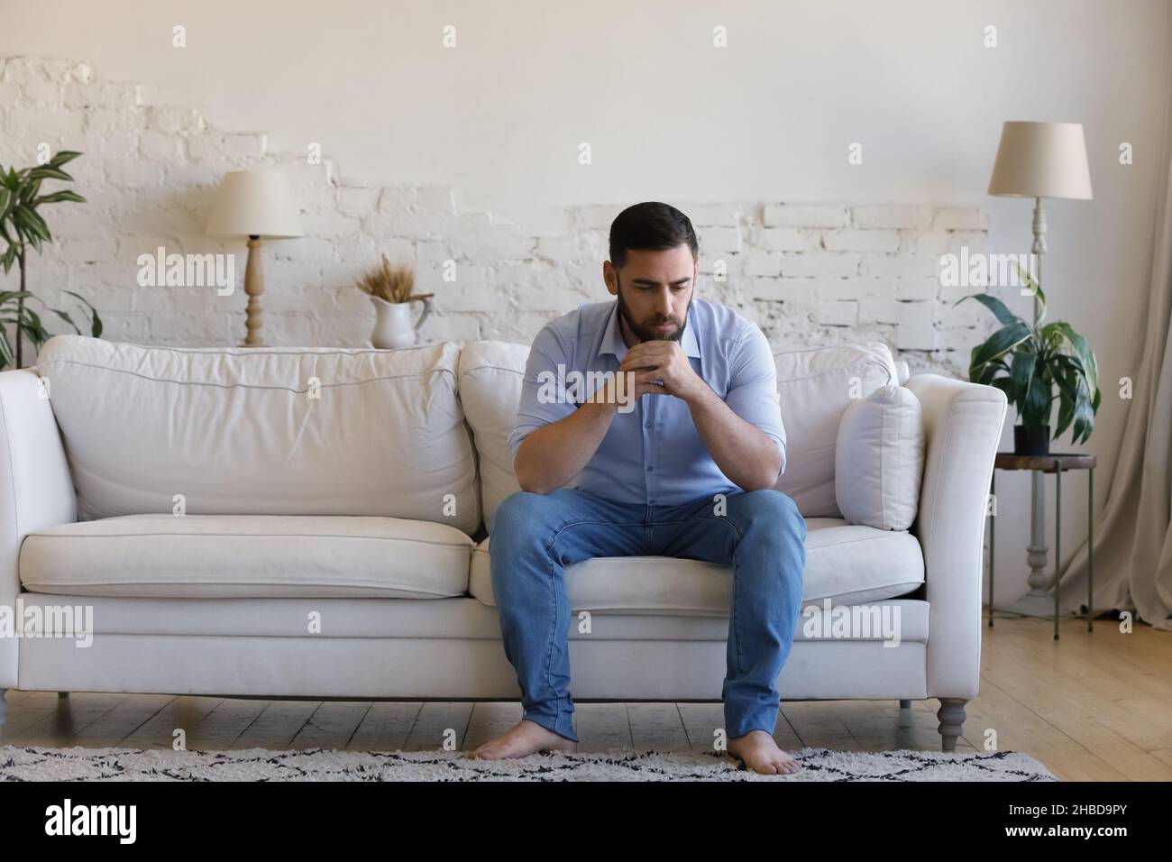 Pensive unhappy young man suffering from problems. Stock Photo