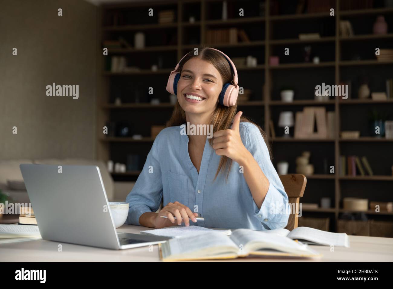 Happy relaxed beautiful young woman in earphones holding video call ...