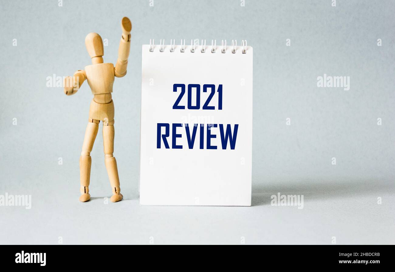 2021 review text on notepad with wooden doll, year end business concept Stock Photo