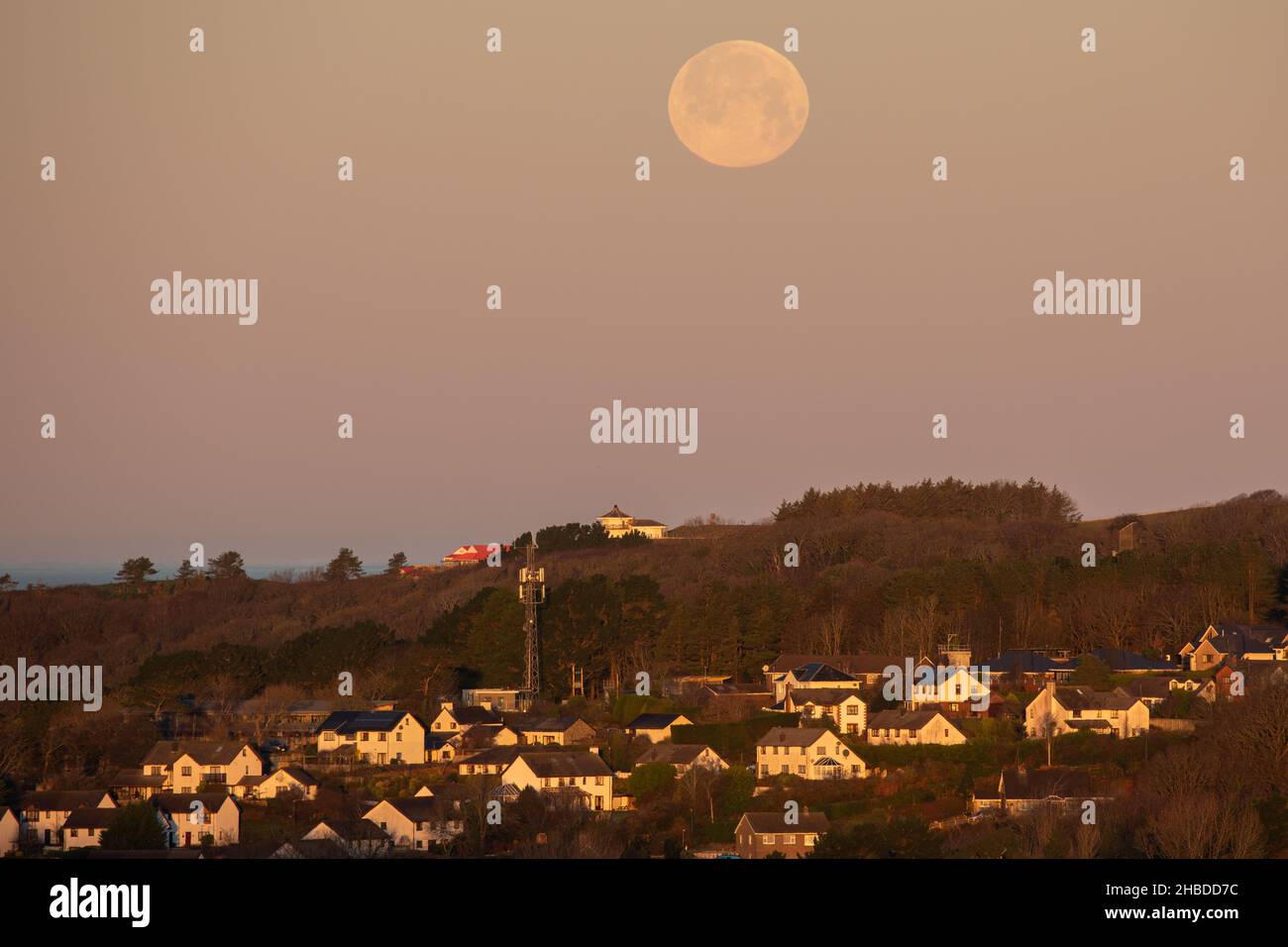 Aberystwyth, Ceredigion, Wales, UK. 19th December 2021  UK Weather: Cold frosty morning in Aberystwyth, as the full moon begins to set behind Constitution hill and over the west coast. © Ian Jones/Alamy Live News Stock Photo