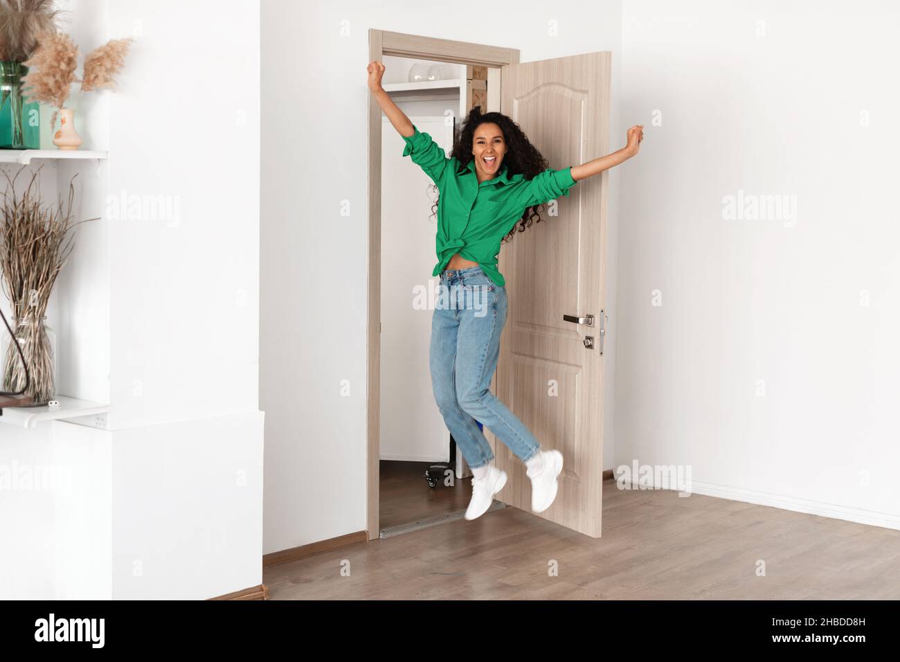Portrait of excited emotional woman jumping in apartment Stock Photo