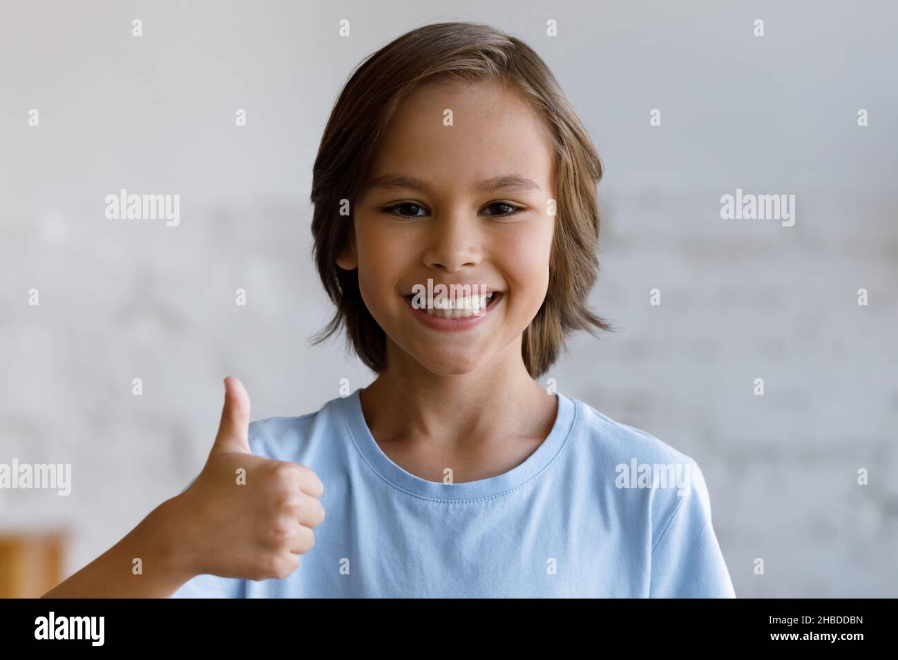 Smiling teenage boy showing thumbs up gesture Stock Photo - Alamy