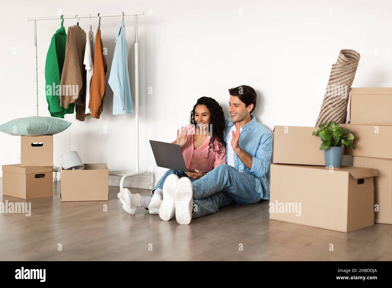Happy millennial couple using laptop after relocation Stock Photo