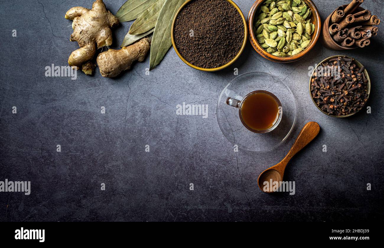 A top view of a cup of tea and Indian seasonings on a table Stock Photo