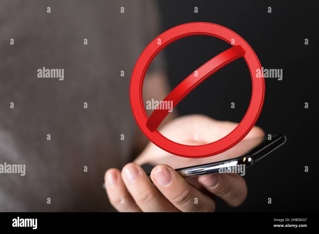 A 3D rendered red stop icon floating over a mobile phone Stock Photo ...