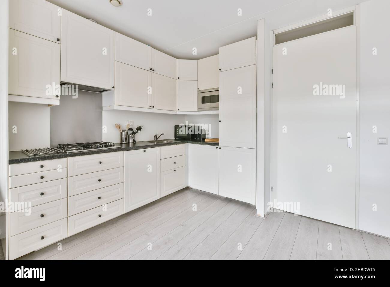 Minimalist corner kitchen with microwave and oven Stock Photo