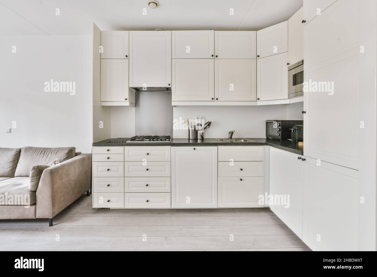 Minimalist corner kitchen with microwave and oven Stock Photo