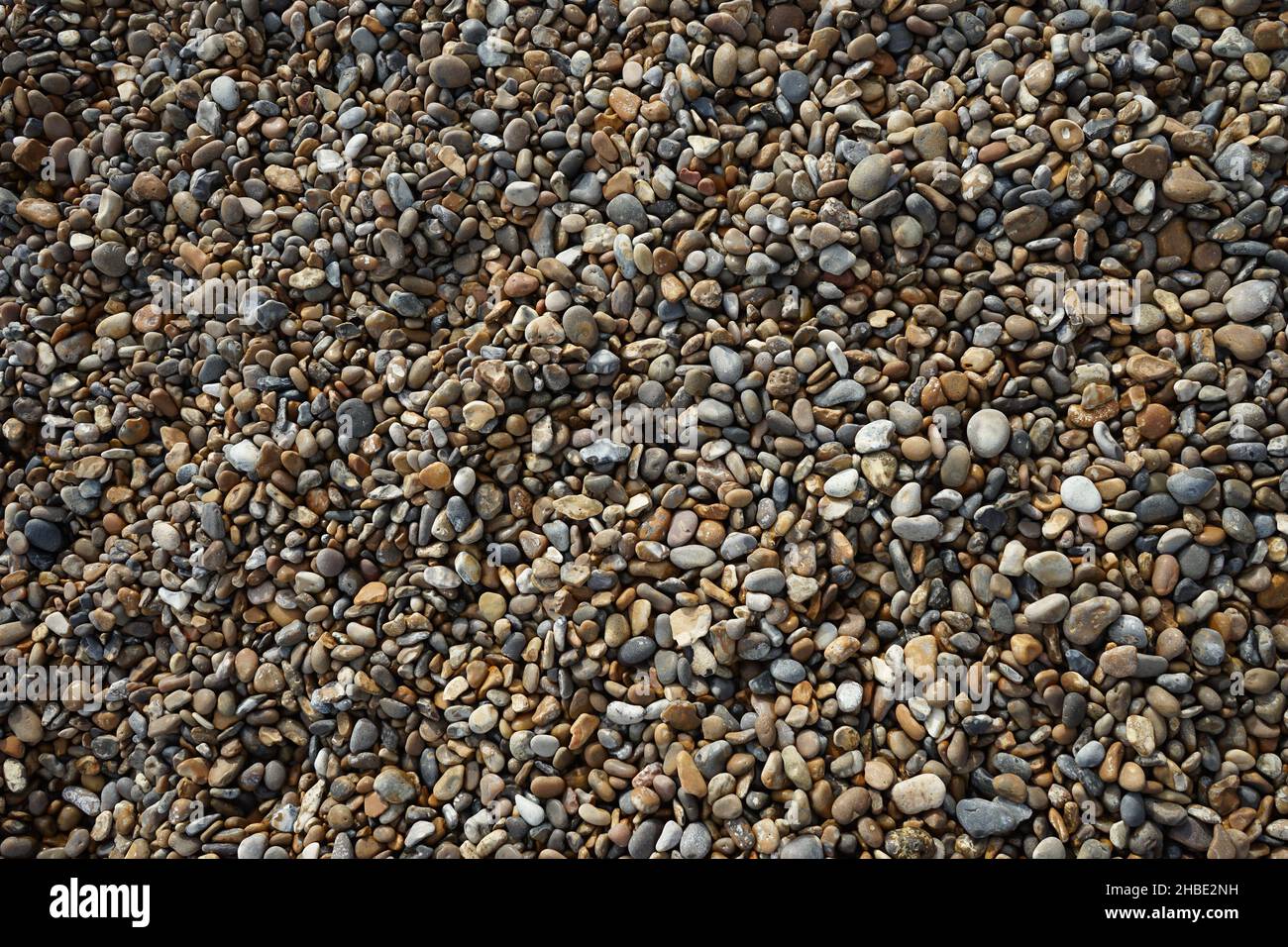 Looking down at an area of pebbles on a beach Stock Photo